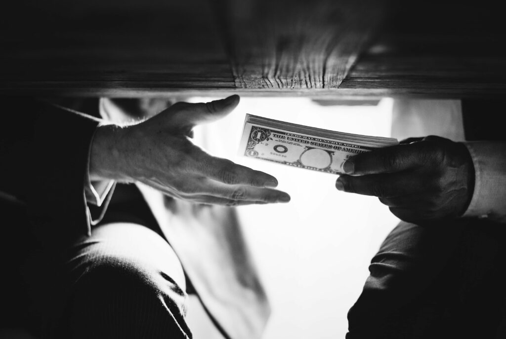 2 hommes passant de l'argent sous la table